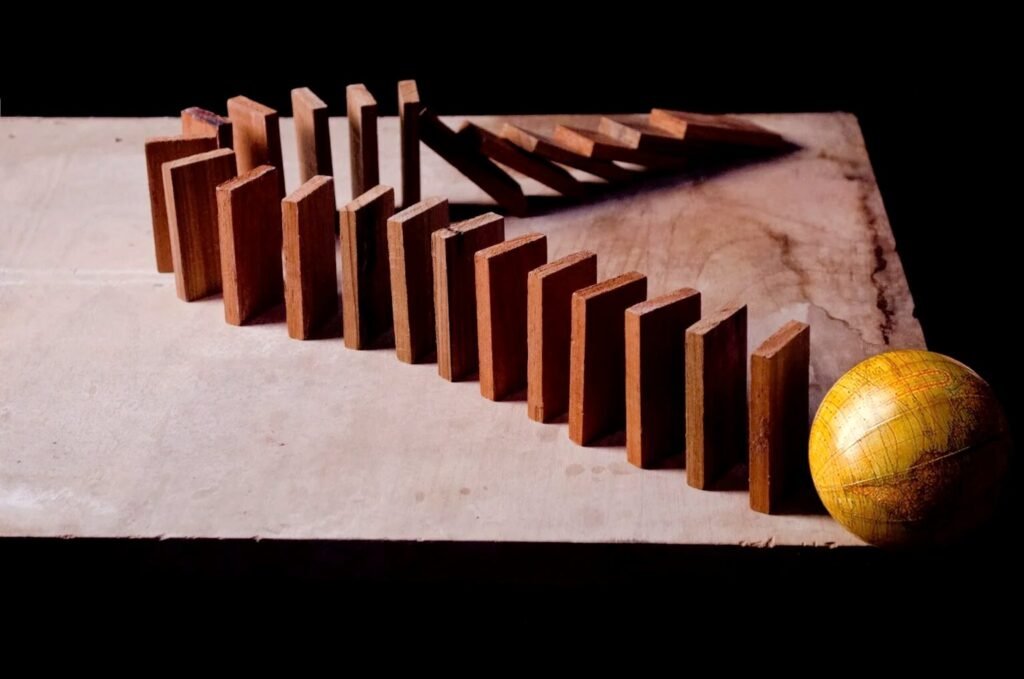 How to Automate the Boring Parts of Remote Work (Without Automating Yourself) Wooden dominoes standing in a curved line next to a small globe