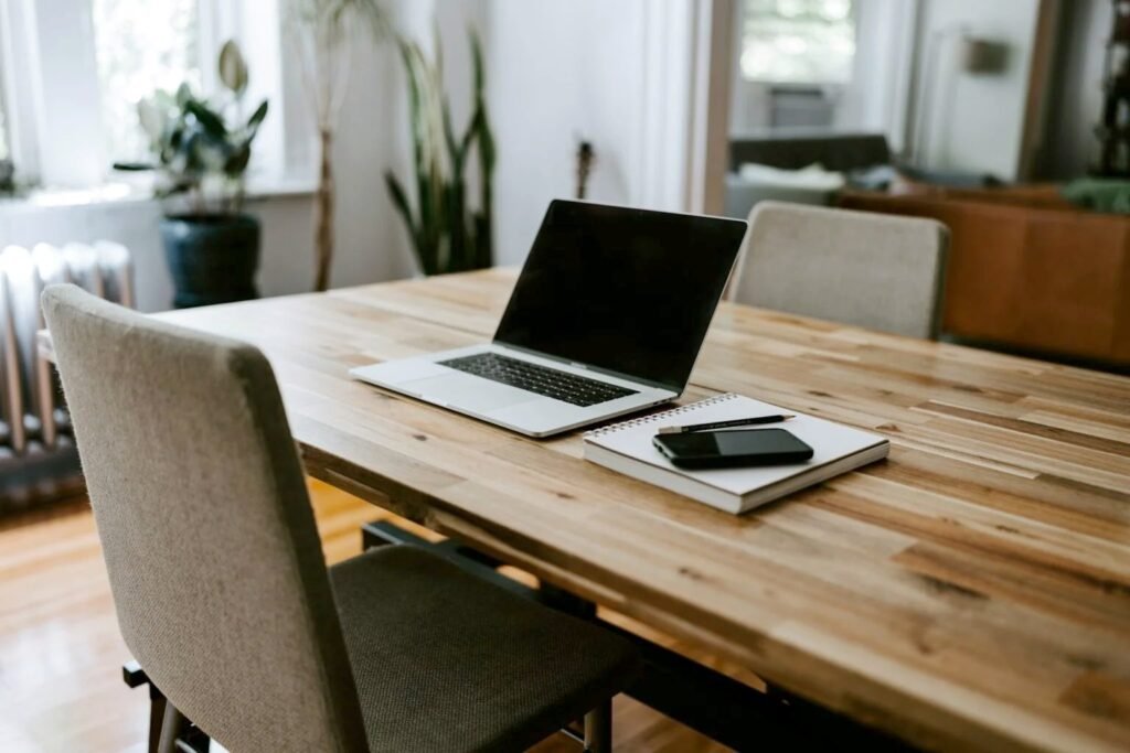 How to Actually Switch Off When Your Office Is Your Home Closed-for-the-day home office with a laptop, notebook and phone on a wooden table