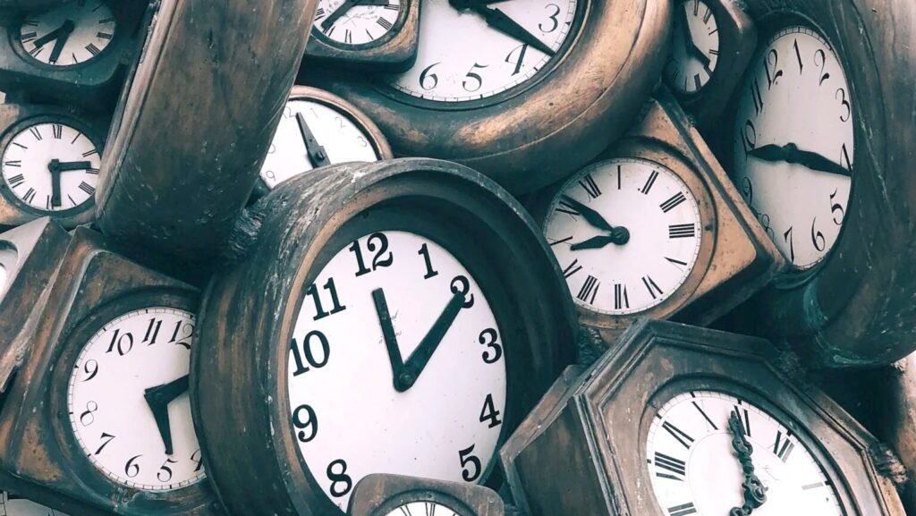How to Work Across Time Zones Without Burning Out A pile of vintage clocks each showing a different time