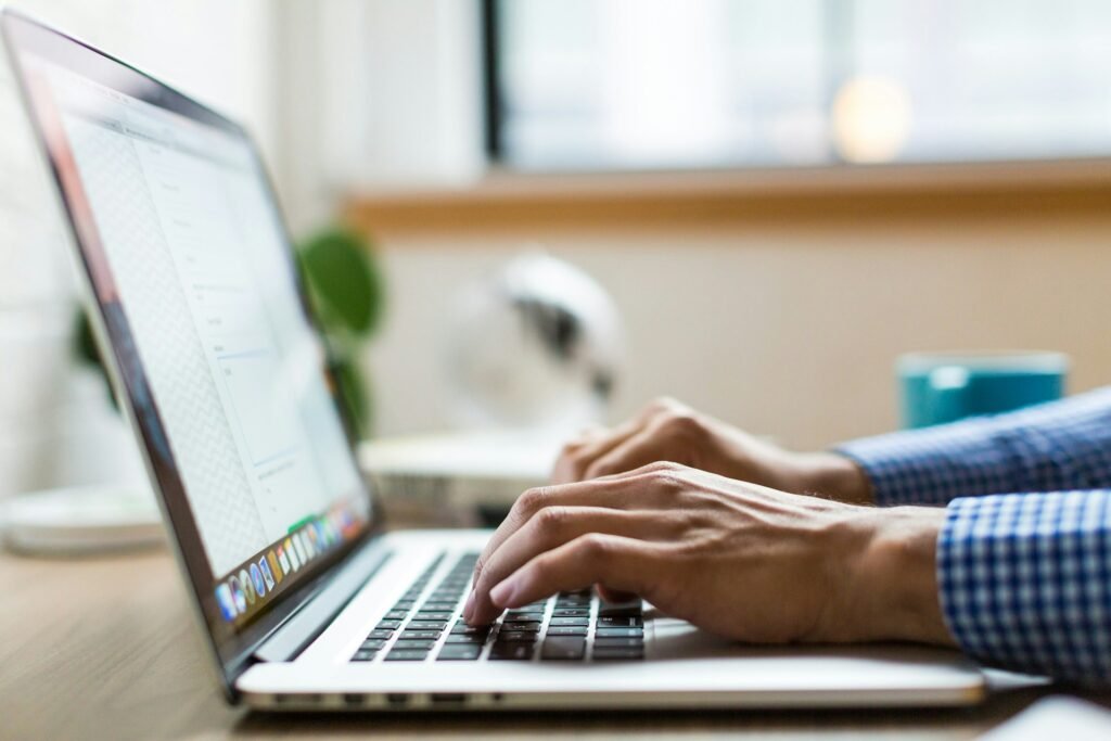 Hands typing an email in English on a laptop