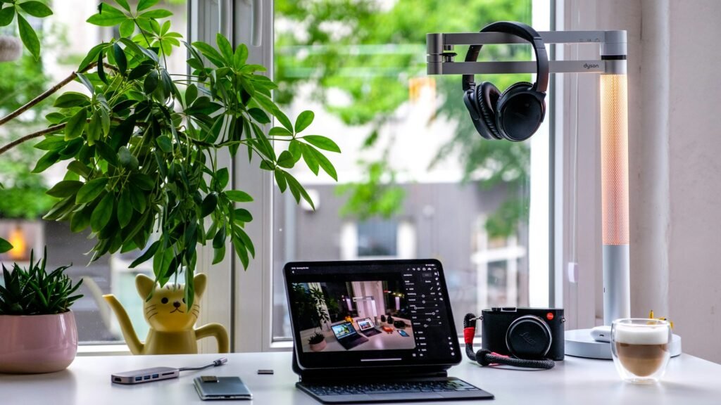 Bright desk with a tablet showing a video editor, a camera and headphones